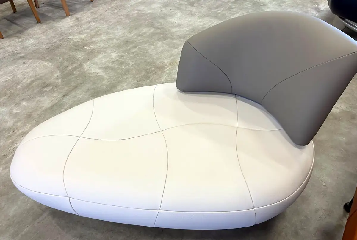 Organisch gevormd daybed met een wit leren ligvlak en een grijze leren rugleuning.
